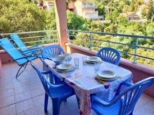 a table with chairs and plates on a balcony at Magnifiques appartements vue mer panoramique in Théoule-sur-Mer