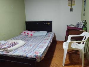 a small bedroom with a bed and a chair at Alojamiento Don Luis in Popayan