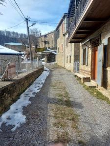 an alley with snow on the ground next to buildings at Vila Ceku in Dardhë