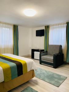 1 dormitorio con 1 cama y 1 silla en Casa Lazar en Topliţa