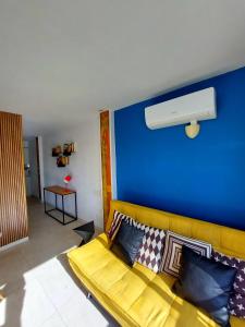 ein gelbes Sofa im Wohnzimmer mit blauer Wand in der Unterkunft Ducado of the Sea in Benidorm