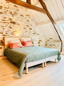 a bed in a room with a stone wall at Le Cinquante in Groix