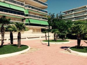 een groot gebouw met palmbomen op een binnenplaats bij CÓMODO APARTAMENTO - CERCA DE LA PLAYA - PARKING in Salou