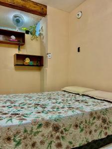 a bedroom with a bed with a floral bedspread at Carnaval de Salvador no coração da Sereia - Ondina in Salvador