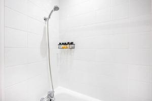een douche met een douchekop in de badkamer bij Stylish Studio in Leicester Square in Londen