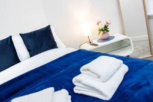 a bedroom with a blue bed with towels on it at Stylish Studio in Leicester Square in London