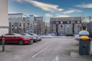 a red car is parked in a parking lot at Union Square modern 2 bedroom apartment in Aberdeen