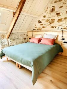 a large bed in a room with a stone wall at Le Cinquante in Groix