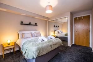 a bedroom with a large bed with towels on it at Union Square modern 2 bedroom apartment in Aberdeen