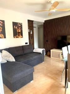 uma sala de estar com um sofá e uma televisão de ecrã plano em Затишна квартира Playa Levante em Santa Pola