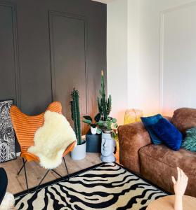 Sala de estar con sofá, sillas y cactus en SamaraS Place en Berlín