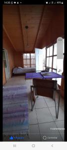Pokój ze stołem, łóżkiem i oknami w obiekcie Hostal Acuariano Piscoelqui w mieście Pisco Elqui