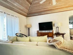 a living room with a white couch and a flat screen tv at A'Viva Grace Bay - Alta3 in The Bight Settlements