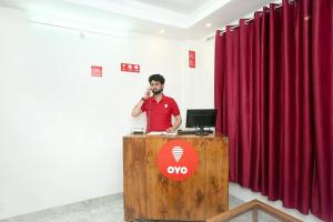 a man standing at a podium talking on a phone at OYO Hotel Sai Stay Inn in Chhota Simla