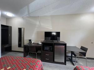 a hotel room with a bed and a table and a desk at Scottish Inns Ronks in Ronks