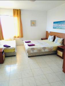 a hotel room with two beds and a window at Kъща за гости Прохлада 3 и 4 етаж in Sinemorets