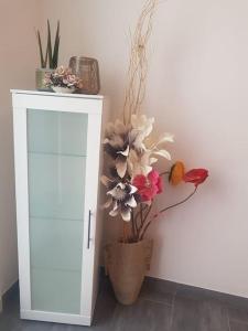 un jarrón lleno de flores junto a un armario blanco en Toni di Rosa, Tavullia centro, en Tavullia