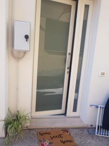 una puerta de cristal de una casa con una planta delante en Toni di Rosa, Tavullia centro en Tavullia