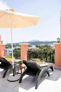 a patio with a table and chairs and an umbrella at Swan House - Panoramic View in Kommeno in Kommeno
