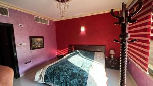 een slaapkamer met een bed in een rode muur bij Tarawneh & Thawabi in Amman