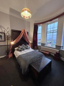 Un dormitorio con una cama grande y una lámpara de araña. en The Office Bar and Restaurant en Dudley