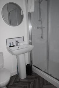 een witte badkamer met een wastafel en een douche bij 9 Plants Yard in Worksop