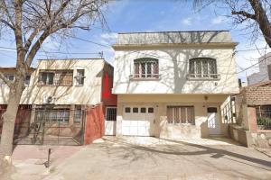 una casa blanca con una valla roja delante de ella en Alojamiento Aloja N1 en Mendoza