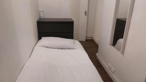 een kleine kamer met een bed en een dressoir bij Bethnal Green Guest House in Londen