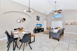 een woonkamer met een tafel, stoelen en een bank bij Lakeview Luxury Oasis in Kissimmee