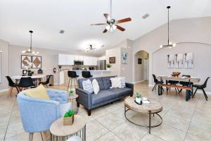 een woonkamer met een blauwe bank en een tafel bij Lakeview Luxury Oasis in Kissimmee