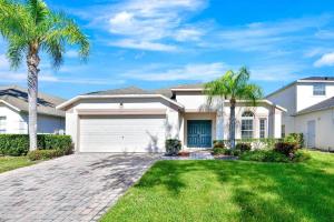 a house with palm trees and a driveway at Lakeview Luxury Oasis in Kissimmee