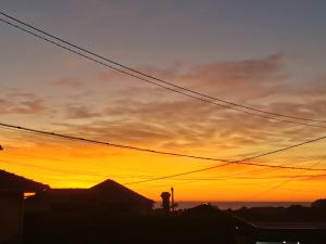 a sunset over a city with power lines at Casa São Pedro Belinho ONLY PILGRIMS in Belinho