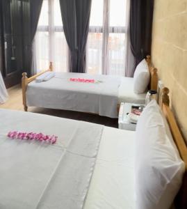 a bedroom with two beds with pink flowers on them at Hayadlı Konak Butik Otel in Gaziantep