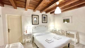 a bedroom with a white bed and a table and chairs at Porta Rossa - Boutique Home in Florence in Florence
