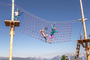 a group of three people jumping over a net at Alpin Family Resort Seetal in Kaltenbach +123 photos