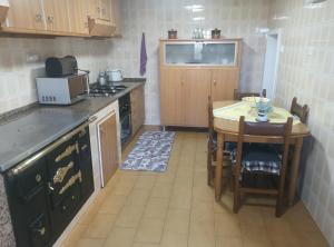 a kitchen with a table and a small table and a kitchen with a tablektop at Casal de Perros 