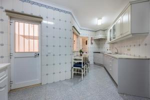 a kitchen with white tiles on the walls and a window at Casa Avenida in Lagos