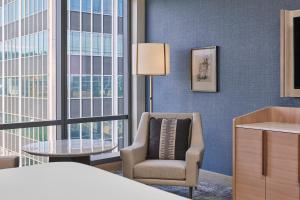 ポートランドにあるThe Ritz-Carlton, Portlandのベッド1台、椅子、窓が備わる客室です。