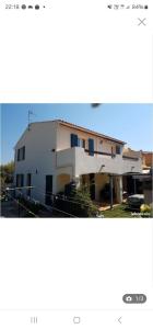 une photo d'un bâtiment blanc avec des fenêtres bleues dans l'établissement Villa Climatisée de 2à 10 personnes Piscine privée 3km MER, à Hyères