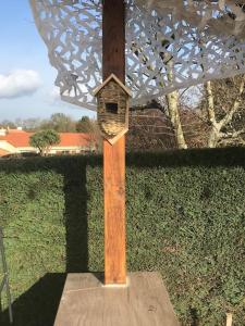 a wooden post with a bird house on it at Charmant T1 privé avec vue et accès piscine in Basse-Goulaine
