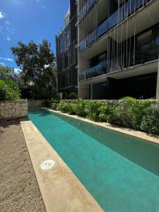a swimming pool in front of a building at Luxury Studio-private individual pool-IIK C409 By Sandy Powerful in Tulum