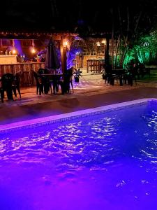 a swimming pool at night with purple lights at Pousada Solar de Itaúna in Saquarema