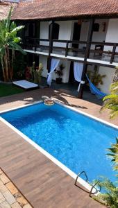 a swimming pool in front of a house at Pousada Solar de Itaúna in Saquarema