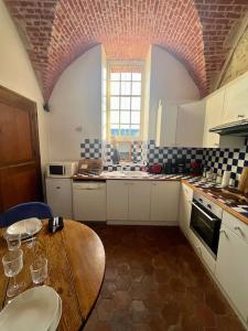 uma cozinha com uma mesa de madeira com copos em Cozy flat in castle near Fontainebleau - 10 min em Fleury-en-Bière