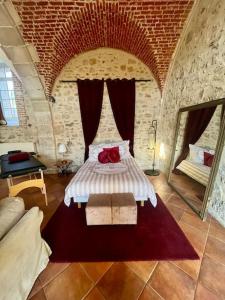 um quarto com uma cama numa parede de tijolos em Cozy flat in castle near Fontainebleau - 10 min em Fleury-en-Bière