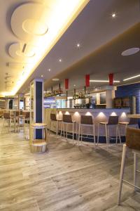 un restaurante con un bar con mesas y sillas en Lungolago Blu Sky, en Locarno
