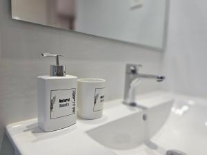 a white soap dispenser on a bathroom sink at Kastrexana Vivienda Turística con tranquilidad y wifi in Bilbao +25 photos