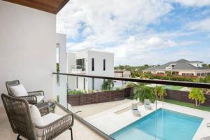 a balcony with two chairs and a swimming pool at Gated Long Bay Villa Near Grace Bay with Pool in Long Bay Hills