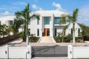 a white house with palm trees in front of it at Private Pool Villa, Long Bay Beach with VIP Extras in Long Bay Hills