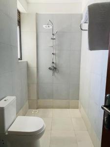 y baño con ducha y aseo. en Azarel homes, en Kampala